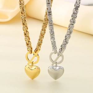 Close-up of gold and silver Byzantine chain necklaces with polished heart pendants and OT clasps