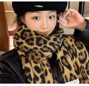 Fashionable leopard print scarf paired with a black beret on a model for winter style