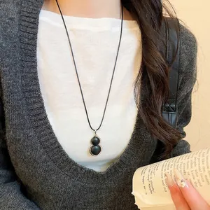 Minimalist black gourd pendant necklace with silver frame on long black cord for women