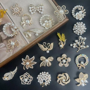Detailed flat lay of vintage crystal brooches with pearl and rhinestone floral designs