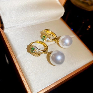 Macro detail of 14K gold plated earrings with green gemstone, zircon and large pearl