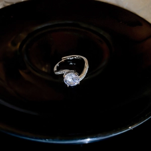 Macro view of a zircon geometric ring with large center stone on a black ceramic plate