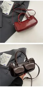 Detail view of retro saddle bags in red and brown leather with front pockets and silver hardware