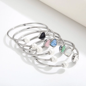 Macro detail of silver bangles with colorful heart crystals and faux pearls