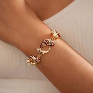 Detail of gold enamel bracelet with red oil drip flower pattern and zircon stones