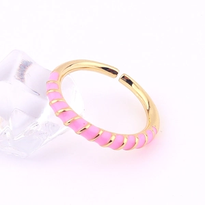Detailed shot of gold adjustable ring with pink enamel spiral texture on ice cube