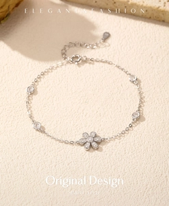 Macro shot of silver flower bracelet with sparkling zircons on textured stone background