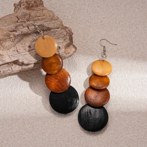 Detail of bohemian wooden beaded drop earrings with natural wood grain and silver hooks