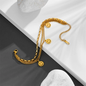 Gold layered stainless steel bracelet with three smile face charms on high-end background