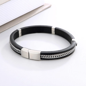 Detail showing masculine black leather wristband with silver metal braided accents