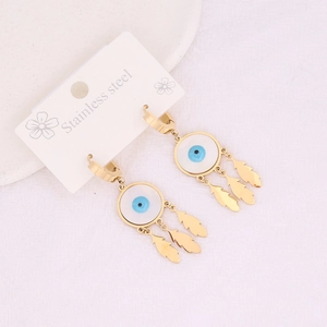 Detail of gold stainless steel earrings with evil eye and feather charms on a display card