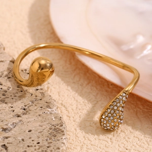 Detail of 18K gold plated open bangle featuring a sparkling water drop zircon design