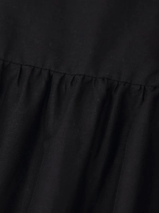 Close-up of black textured fabric with detailed shirring and smocking craftsmanship