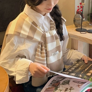 Stylish beige and white striped knitted shawl wrap for women over a white shirt