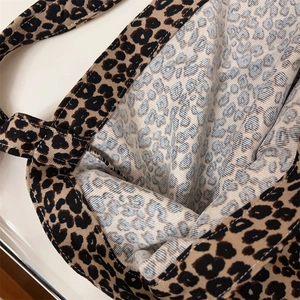 Dettaglio ravvicinato dell'apertura della borsa tote leopardata e cuciture interne rinforzate