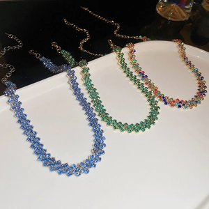 Dettaglio delle collane a rombi con diamanti incastonati in blu, verde e colori misti