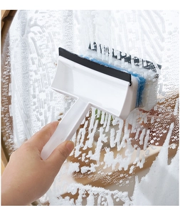 Action shot of the glass wiper squeegee removing foam from a bathroom mirror surface