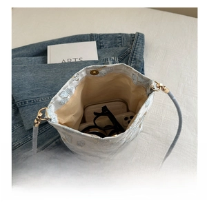 Interior view of large blue embroidery bag showing capacity for phone and wallet