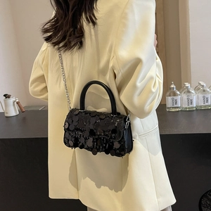 Detail of a chic black sequin shoulder bag with silver chain and elegant handle