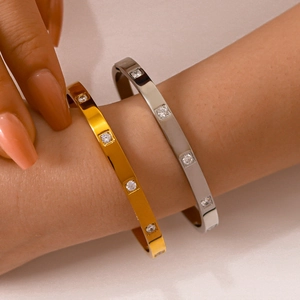 Bracciali in acciaio al titanio oro e argento con zirconi quadrati indossati al polso