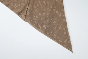 Gros plan détaillé du tissu en dentelle florale marron foncé avec bordures soignées