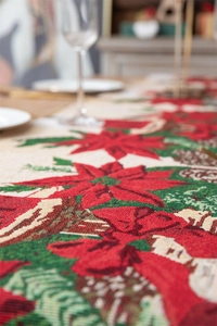 Close-up of woven fabric texture on a beige table runner with red poinsettia patterns