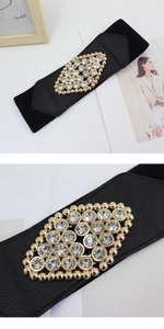 Close-up of a wide elastic waist belt featuring a luxury rhinestone buckle and leather trim