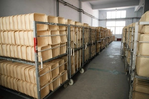 Stack of beige plastic woven storage baskets showing nested design in warehouse