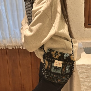 Detail of plush crossbody bag with ethnic floral jacquard and woven rope strap
