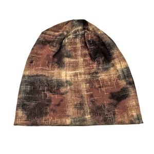 Detail of soft tie-dye knit beanie featuring abstract brown and black marble texture