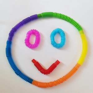 Colorful stretch pop tubes toys arranged in a creative smiley face on white background