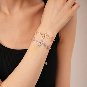 Close-up of butterfly zircon bracelets in rose gold and silver on a woman wrist
