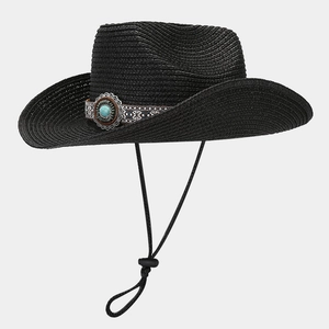 Detail of western straw cowboy hat with ethnic weave band and turquoise ornament buckle