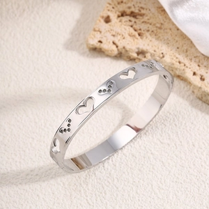 Detail view of silver hollow heart titanium steel bracelet with sparkling diamond accents