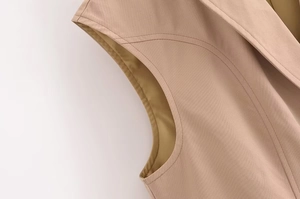 Detailed view of stitching and lining on sleeveless khaki blazer with padded shoulders