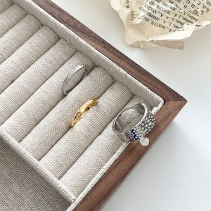 Three-piece set of lava texture stackable rings in silver and gold finish in a jewelry box