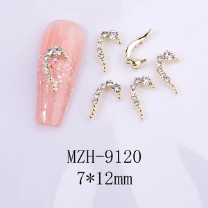 Macro shot of 7x12mm golden heart-shaped nail art charms with white crystals