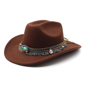 Détail d'un chapeau de cowboy en laine marron avec perles et pendentif pièce