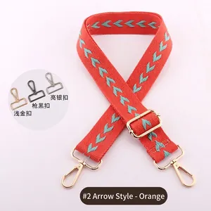 Detail of orange woven bag strap with blue arrow pattern and metal hardware options