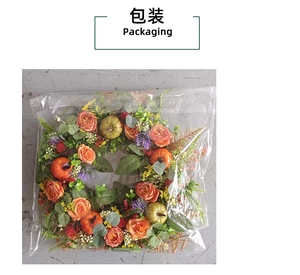 Detail view of autumn wreath with orange roses and pumpkins in plastic packaging