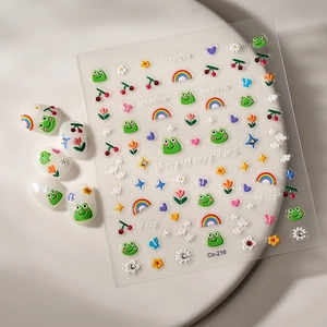 Macro detail of 3D embossed nail stickers featuring cute green frogs and rainbow patterns