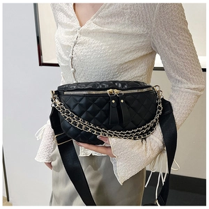 Detail of black quilted fanny pack featuring gold zippers and double metal chain accents