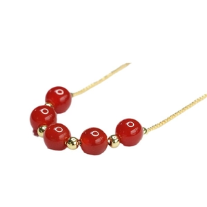 Collier en agate rouge avec perles à motifs et intercalaires dorés sur une chaîne fine