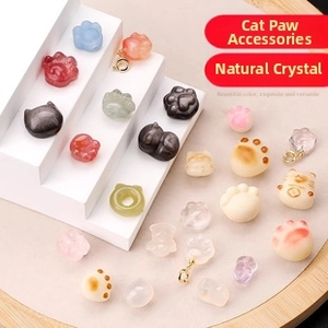 Macro detail of various natural crystal cat paw charms with gold plated metal hooks