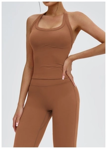 Dettaglio dei leggings da yoga marrone cannella senza cuciture e del top sportivo a vogatore