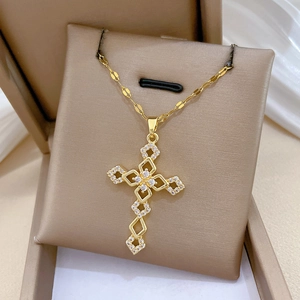 Close-up of a gold cross necklace with sparkling zircons on a brown jewelry display stand