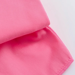 Vue détaillée de la texture du tissu en microfibre rose et des coutures d'un ensemble d'été