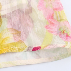 Détail de l'ourlet de robe en mousseline fleurie avec coutures et motif floral rose
