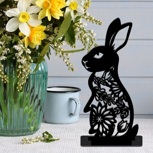 Detail of black cutout Easter bunny silhouette with floral patterns on a white table