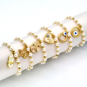 Set aus Gold- und Perlenarmbändern mit Bienen- Stern- Herz- und Evil Eye-Anhängern